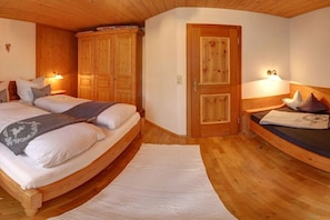 Een slaapkamer met een houten bed, een kledingkast en een deur.
