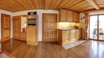 A wooden interior with a kitchen area, including cabinets, a stove, and a sink.