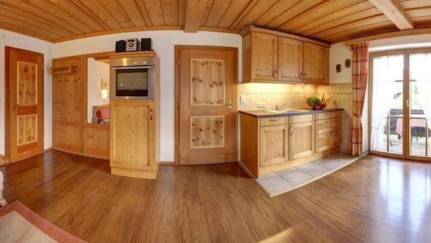 A wooden interior with a kitchen area, including cabinets, a stove, and a sink. - Farmhouse with 1 bedroom (Inzell, Deutschland)