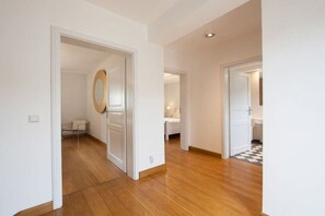 A hallway with wooden flooring, white walls, and doors leading to different rooms. - Winemaker's House for 6 people (Wasserliesch)
