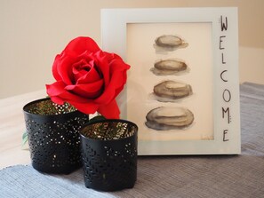A framed welcome sign with four oval shapes and a red rose in a black decorative container. - Apartment 'Appartement Am Rathaus' with Wi-Fi (Erdmannhausen)