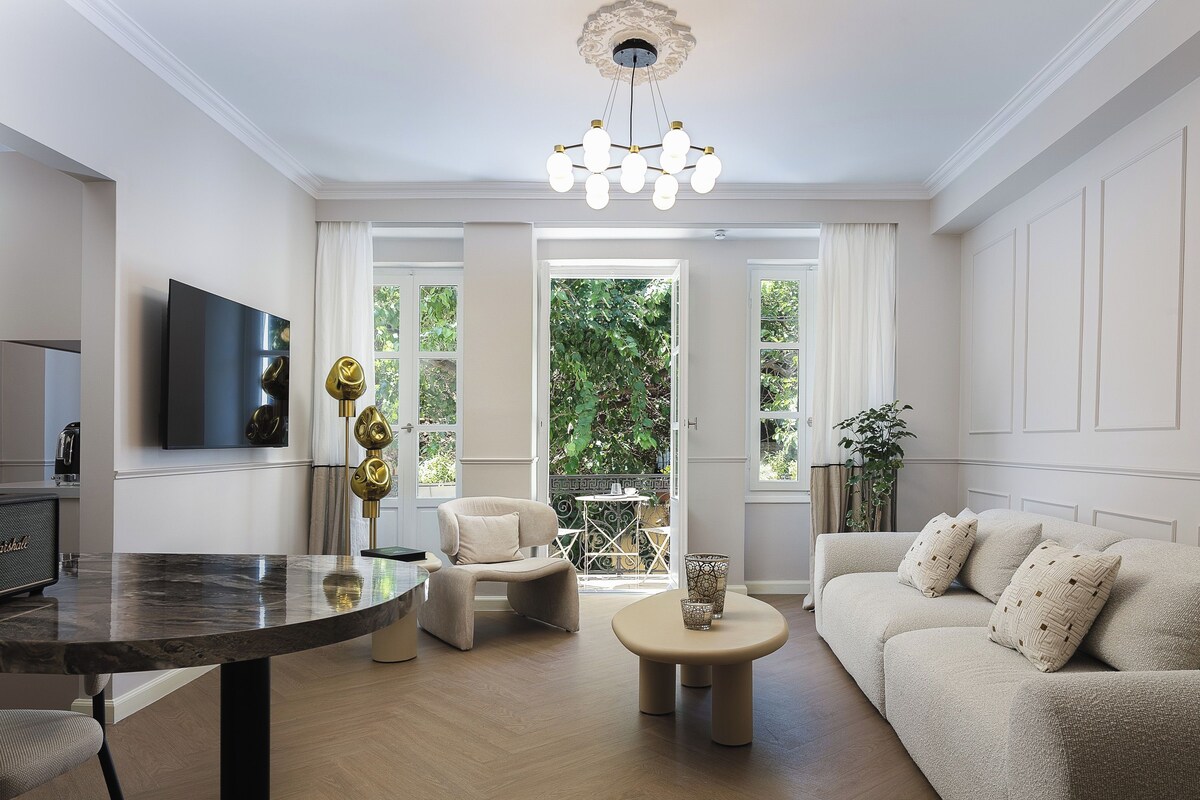 A living room with a sofa, a coffee table, a TV, and a dining area with a table and chairs.