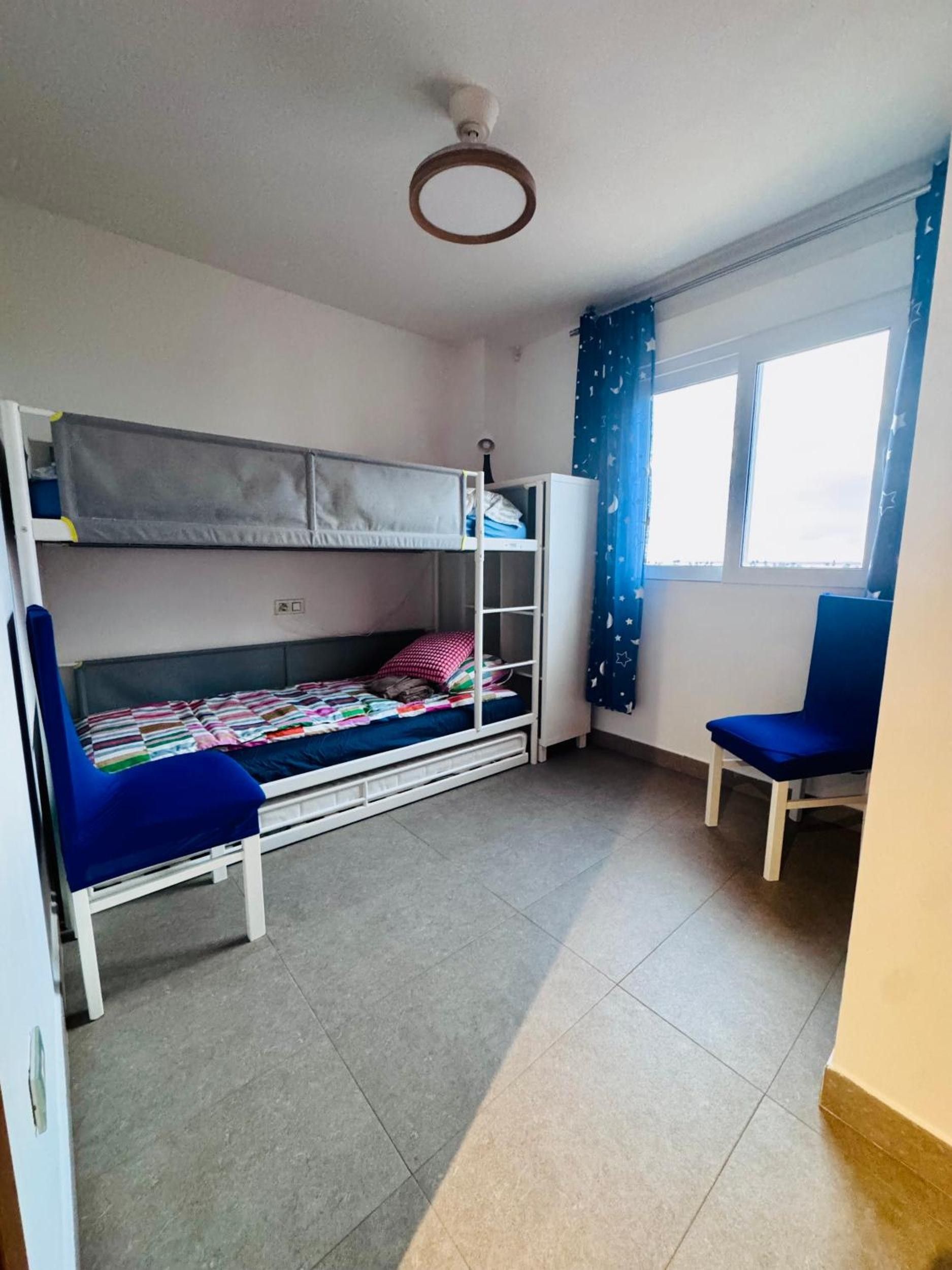 Ein Zimmer mit Etagenbetten, einem Schreibtisch und einem Stuhl.
