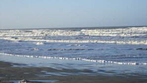 A beach with waves approaching the shore. - Holiday apartment with 3 bedrooms (Norderney)