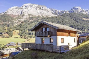 A wooden chalet with a balcony, set against a mountainous backdrop. - Cabin in Annaberg with swimming pool (Annaberg)