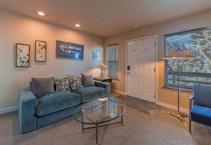 A living room with a sofa, a glass coffee table, and a door with a window.