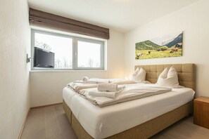 A bedroom with a bed, a window, a painting, and a television. - Apartment in Radstadt with swimming pool (Radstadt)