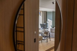 A view through a wooden door into a room with a dining table, chairs, and a sofa. - Premium penthouse with 3 bedrooms (Oberndorf in Tirol)