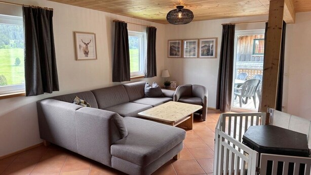 Una sala de estar amoblada con sofá, sillones, una mesita de centro y vistas al exterior.