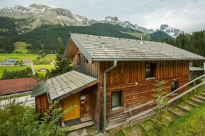 A wooden cabin with a sloped roof, a small porch, and a view of a mountainous landscape. - Cabin in Annaberg with swimming pool (Annaberg)