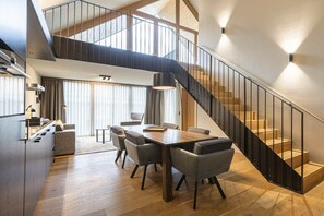 Ein modernes Interieur mit Essbereich, Küche und Treppe.