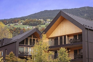 A modern building with a sloped roof, large windows, and balconies. - Apartment in Schruns with swimming pool (Schruns)