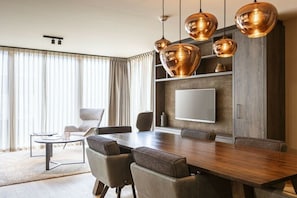 A modern dining area with a wooden table, leather chairs, and pendant lighting. - Apartment in Schruns with swimming pool (Schruns)
