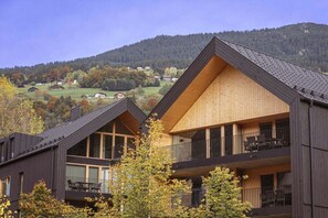 A modern building with a sloped roof, large windows, and balconies. - Apartment in Schruns with swimming pool (Schruns)