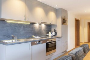 A modern kitchen with a built-in oven, microwave, and a coffee machine. - Apartment with 2 bedrooms (Westendorf)