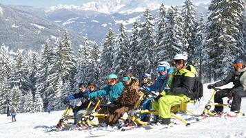 Un gruppo di persone su un motoslitta in una zona montana innevata.