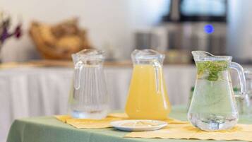 A table with two pitchers and a glass jug, possibly containing beverages, on a tablecloth.