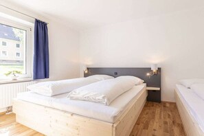Una camera da letto con un letto matrimoniale, una finestra con tende e un lampadario a parete.