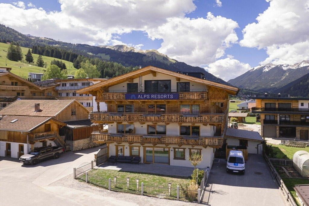 Un edificio de varios pisos con un cartel que dice 'ALPS RESORTS'.