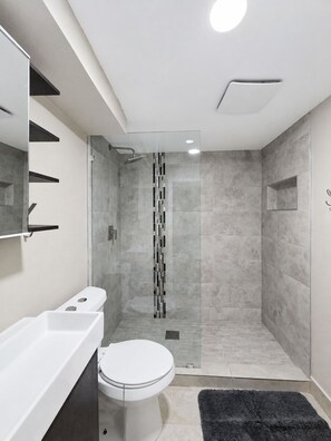 A modern bathroom with a shower, toilet, and sink. - Spacious 5BR Denver Home Near Downtown & Hospitals (Denver)