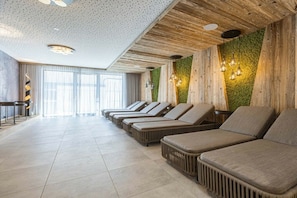 A spa area with a row of massage chairs, a wooden ceiling, and a green wall. - Apartment in Fügen with swimming pool (Fügen)