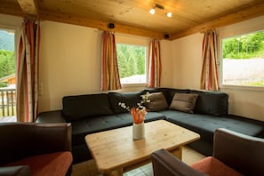 Una habitació acollidora amb un seient modular, una taula de fusta i cortines.