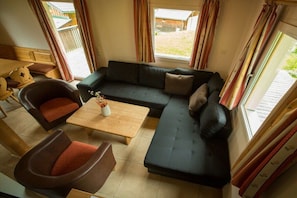 Ein gemütlicher Wohnbereich mit einer Couch, Sesseln und einem Couchtisch.