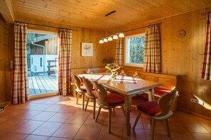 A wooden interior with a dining table, chairs, and a bench. - Cabin in Annaberg with swimming pool (Annaberg)