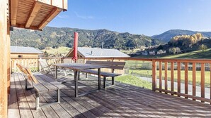 A wooden deck with a table and benches, overlooking a mountainous landscape. - Cabin in Steinach am Brenner with sauna (Steinach am Brenner)