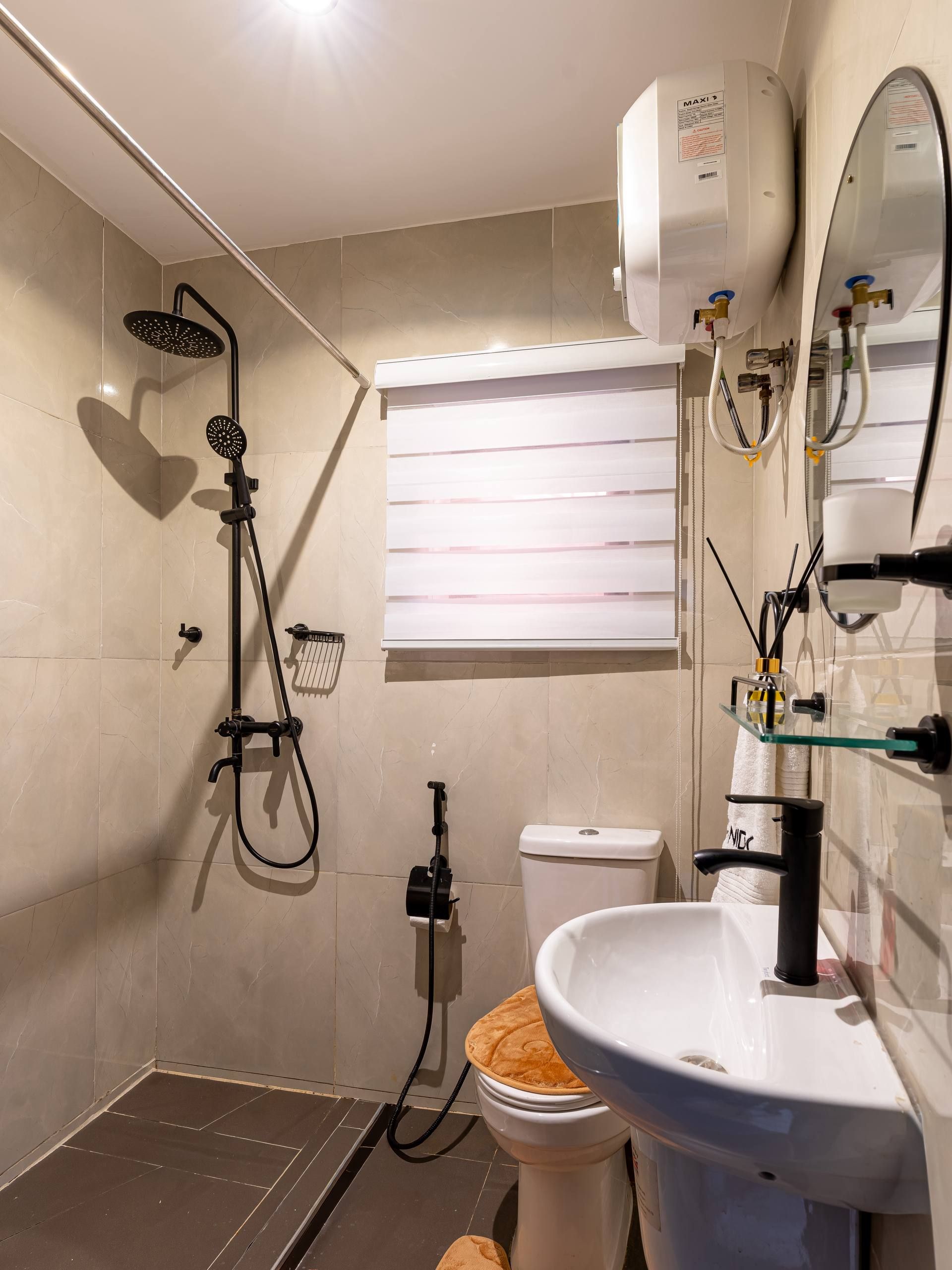 Un baño con ducha, inodoro, lavamanos y espejo.
