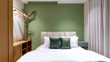 Un dormitorio con cama, mesita de noche, cómoda y lámpara de pared.