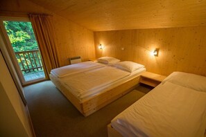 Ein Schlafzimmer einer Holzhütte mit einem Bett, Nachttischen und einem Balkon.