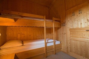 Ein Zimmer mit einem Holzbettgestell, einer kleinen Hängekonsole und einer Matratze.