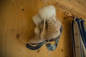 Une paire de bottes à bordure de fourrure, accrochées à un mur en bois.