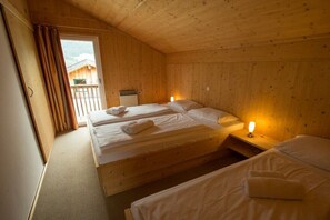 Eine Holzhütte mit zwei Betten, einem Balkon und einem Fenster.