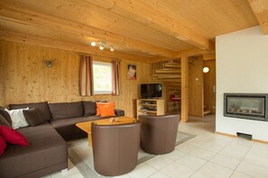 Un intérieur en bois avec un canapé, une table basse et un téléviseur.