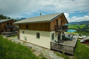 A chalet with a balcony, a deck, and a view of a mountainous landscape. - Cabin in Annaberg with swimming pool (Annaberg)
