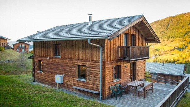 A wooden cabin with a balcony, a deck, and a view of a mountainous landscape. - Cabin in Annaberg with swimming pool (Annaberg)