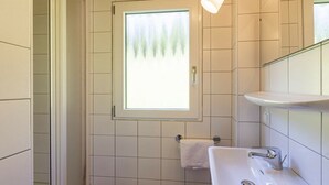 A bathroom with a window, a sink, and a towel rack. - Cabin in Annaberg with swimming pool (Annaberg)