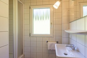 A bathroom with a window, a sink, and a towel rack. - Cabin in Annaberg with swimming pool (Annaberg)