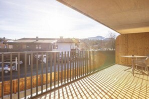 A balcony with a metal railing, a table, and chairs. - Premium holiday apartment with 1 bedroom (Oberndorf in Tirol)