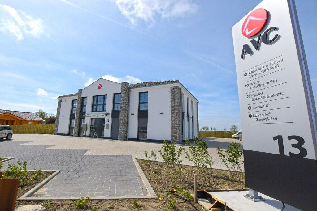 Un bâtiment moderne avec une enseigne indiquant qu’il s’agit du numéro 13.