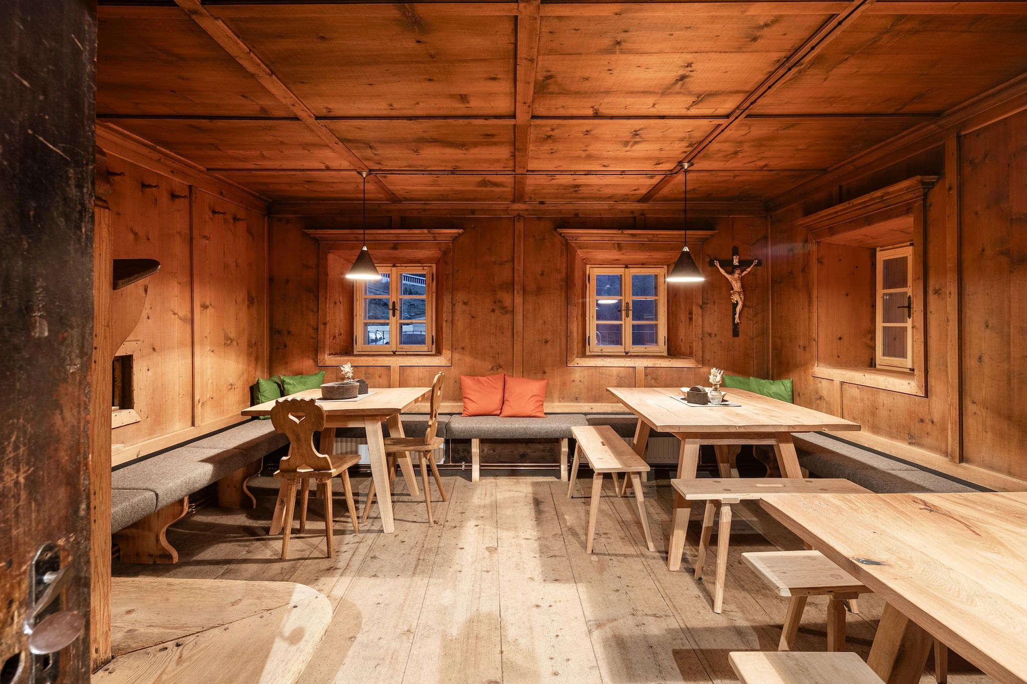Ein Holzinterieur mit Essbereich, Bänken und einer Couch.