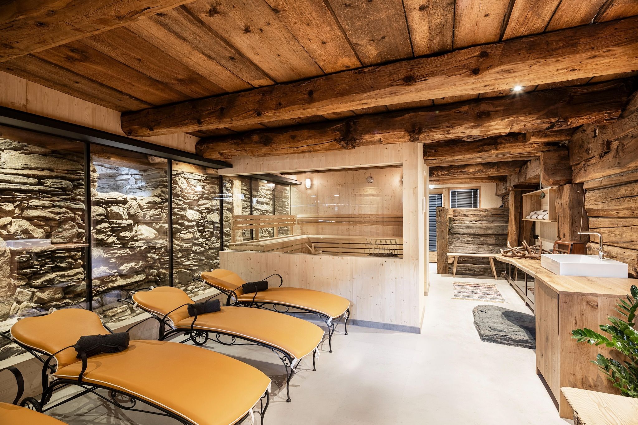 A rustic interior with wooden beams, stone walls, and a reception area with a wooden counter.
