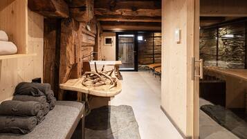 Une salle de spa aux murs en bois, avec un banc en pierre et une table ornée de sculptures en bois.