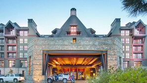 A multi-story building with a stone facade, a large garage entrance, and multiple balconies. - Unparalleled Luxury and Family Adventure at The Ritz-Carlton Club- 4 Bd. Res (Truckee)