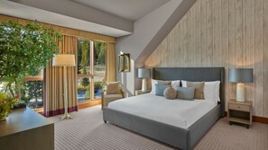 A modern hotel room with a large bed, two bedside tables, a nightstand, a window with curtains, and a view of trees. - Unparalleled Luxury and Family Adventure at The Ritz-Carlton Club- 4 Bd. Res (Truckee)
