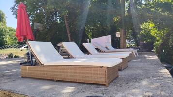 Outdoor lounge chairs with a brick base, arranged in a row.