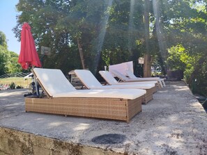 Een rij met lounge fauteuils buiten, met een bakstenen onderstel.