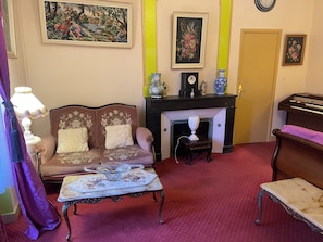 A living room with a sofa, a table, a fireplace, and a clock on the wall. - 18TH-CENTURY CLAIREFONTAINE GARCHIZY CASTLE (Garchizy)